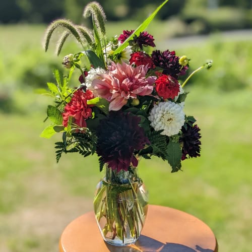 Mixed bouquet of dahlias and chrysanthemums in a clear glass vase