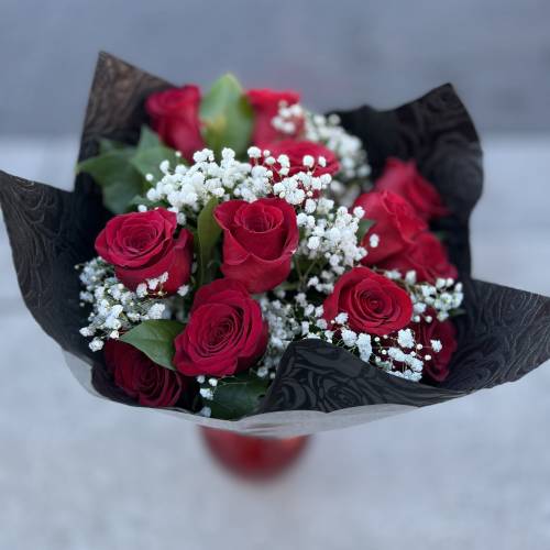 Bouquet of red roses with white baby's breath in black wrap