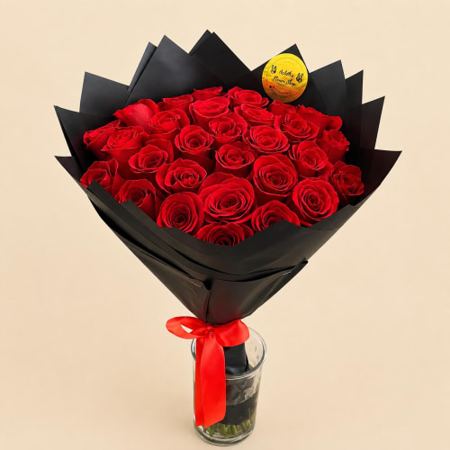Bouquet of red roses wrapped in black paper with a red ribbon