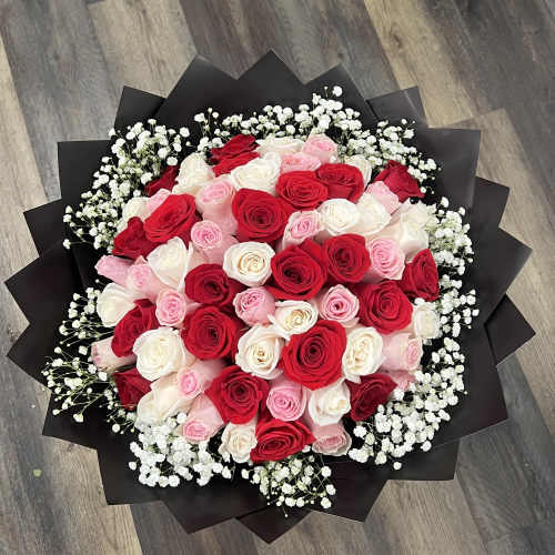 Bouquet of red, pink, and white roses with baby's breath in black wrap