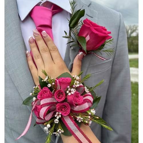 Pink rose boutonniere and wrist corsage on a gray suit