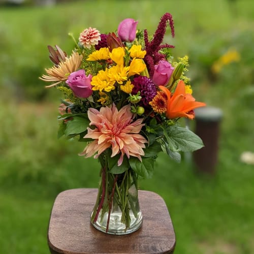 Mixed bouquet of bright flowers in a clear glass vase