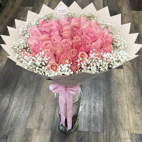 Bouquet of pink roses with white baby's breath in a glass vase
