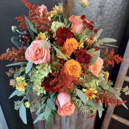Mixed bouquet of pink and orange roses with red and yellow accents