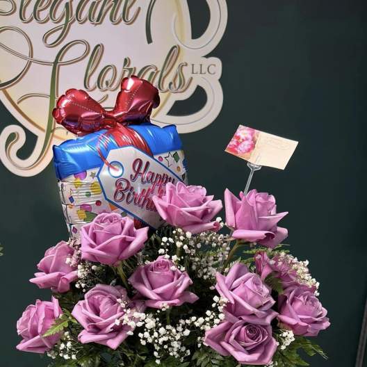 Pink rose bouquet with a birthday balloon in a glass handbag vase