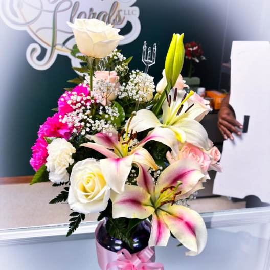 Mixed bouquet with white lilies, roses, and pink carnations in a vase