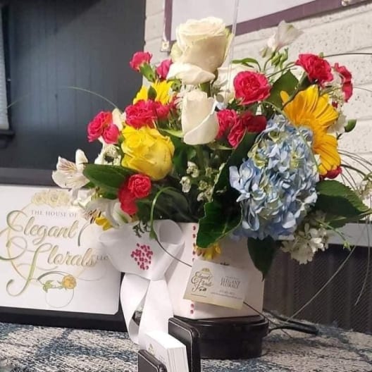 Mixed bouquet of roses, hydrangea, and sunflowers in a white box with ribbon