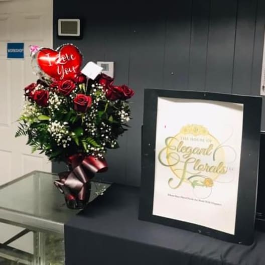 Red rose bouquet with a heart balloon and ribbon in a vase