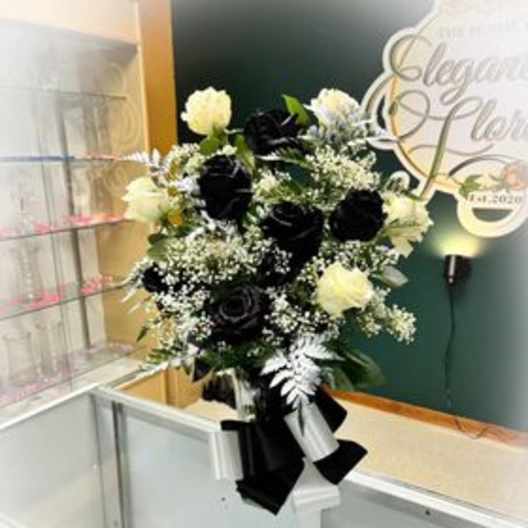 Black and white floral arrangement in a vase with ribbon