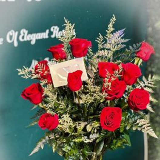 Bouquet of red roses in a green vase with a ribbon bow