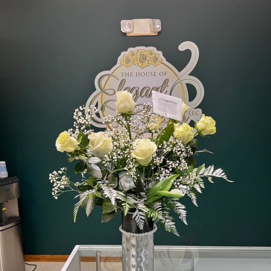 Cream rose arrangement in a silver vase with baby's breath