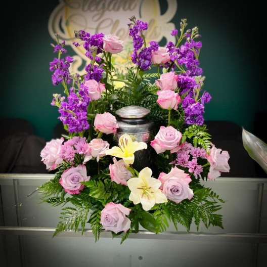 Pink and purple floral arrangement with lilies in a silver urn