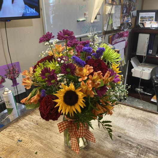 Mixed bouquet in a glass vase with a gingham ribbon