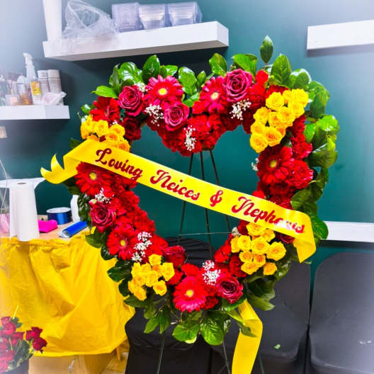 Heart-shaped floral standing spray with red, pink, and yellow flowers