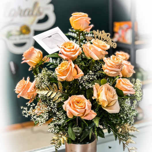 Peach roses arranged in a glass vase with gold accents