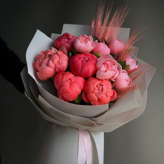 Bouquet of pink peonies wrapped in pale paper