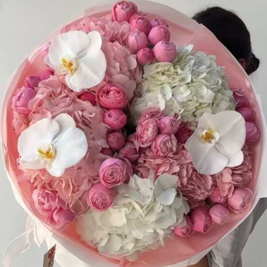 Round bouquet of pink and white flowers with orchids and hydrangeas