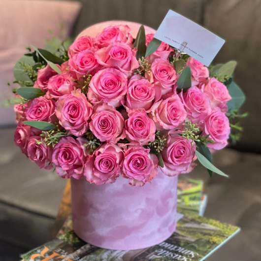 Pink roses arranged in a lavender hatbox