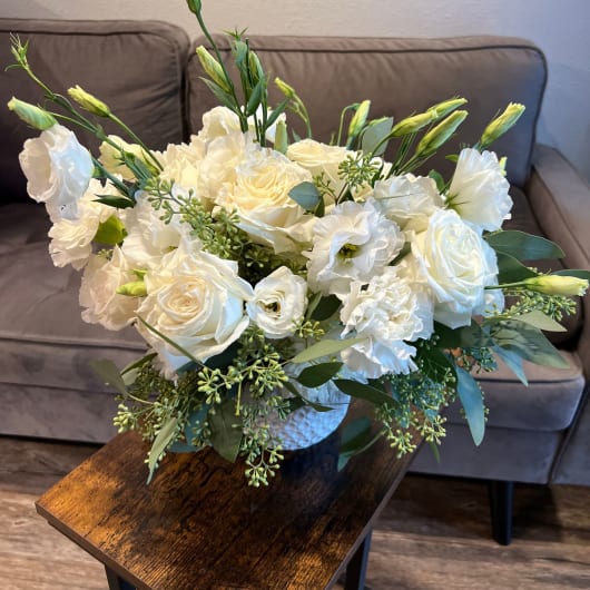 White rose and lisianthus bouquet in a textured vase