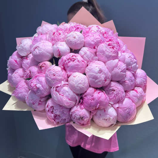 Large bouquet of pink peonies wrapped in pink and cream paper
