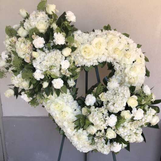 Heart-shaped white floral wreath on an easel