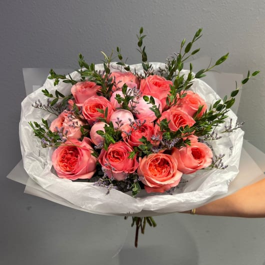 Bouquet of coral pink roses with small purple filler flowers