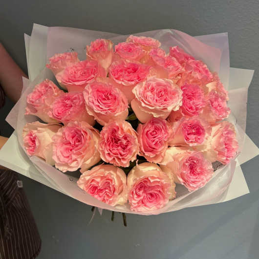 Bouquet of pink roses wrapped in pale paper