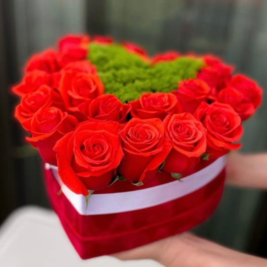 Heart-shaped box of red roses with green filler