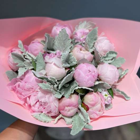 Pink peony bouquet wrapped in pink paper with silvery foliage