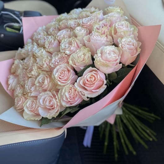 Bouquet of pale pink roses wrapped in pink paper