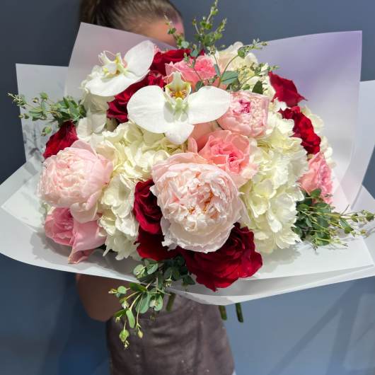 Bouquet of red, pink, and white flowers with white orchids