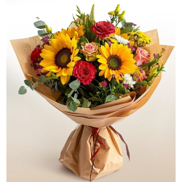 Bouquet of sunflowers, roses, and carnations wrapped in brown paper