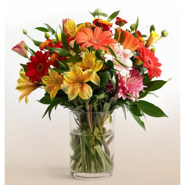 Mixed bouquet of colorful flowers in a clear glass vase
