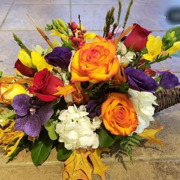 Bouquet of orange, red, purple, and white flowers with autumn leaves