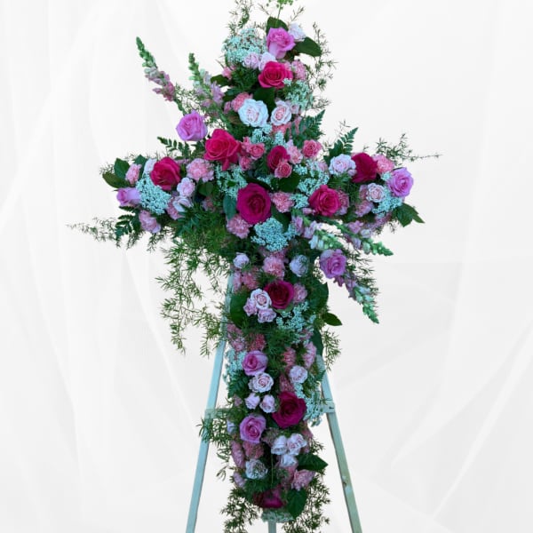 Large pink and white floral cross on a stand