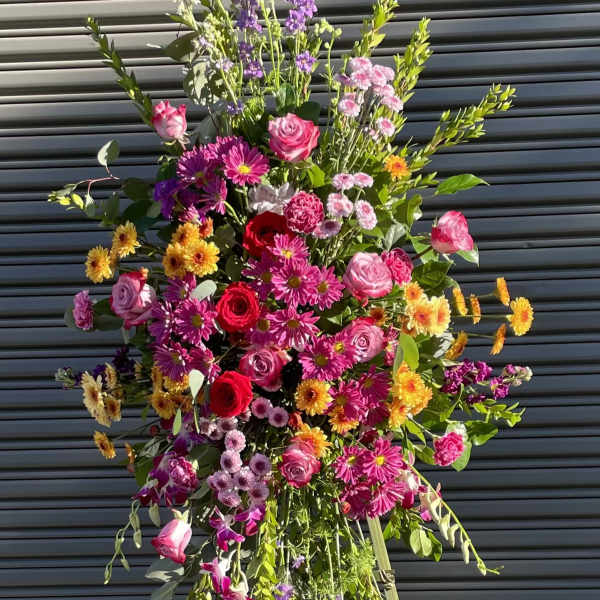 Tall standing floral spray with pink, purple, and yellow flowers