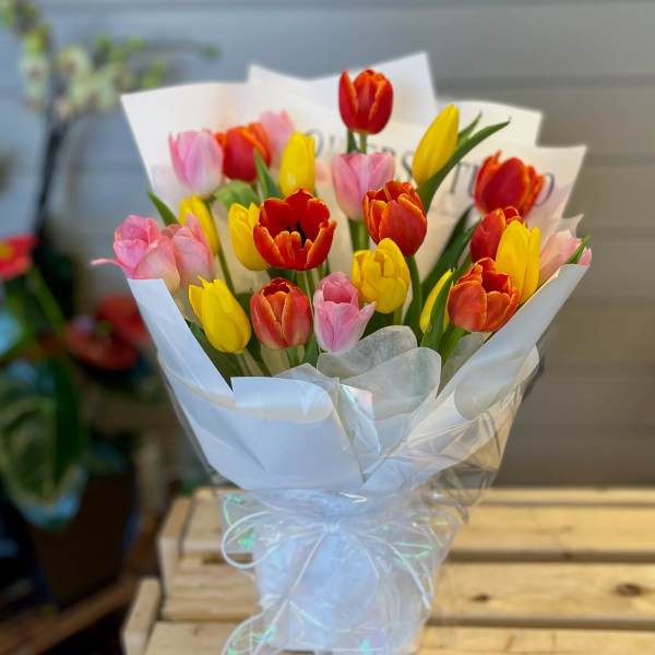 Bouquet of multicolored tulips wrapped in white paper
