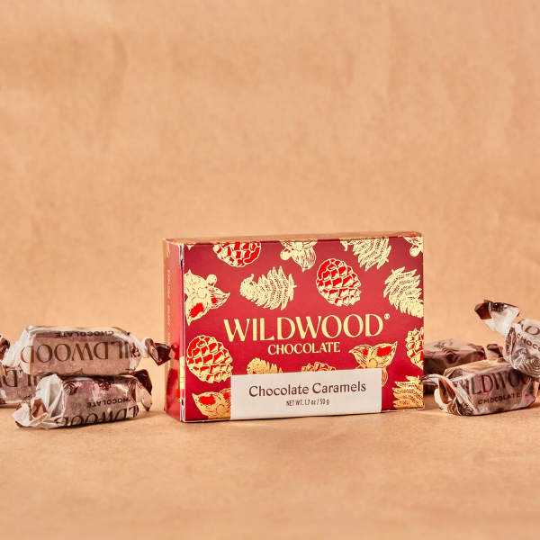 Box of Wildwood chocolate caramels with wrapped candies on a tan background