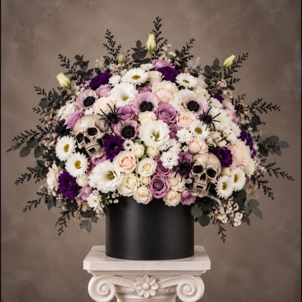 Large floral arrangement in a black box with two skull decorations