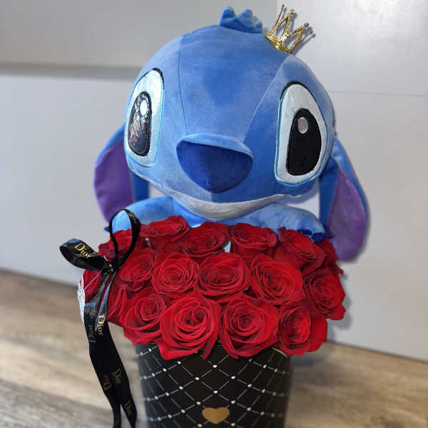 Blue plush toy with a crown above a box of red roses