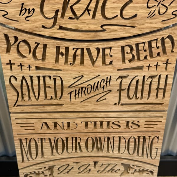 Wooden sign with cutout text reading "you have been saved through faith."