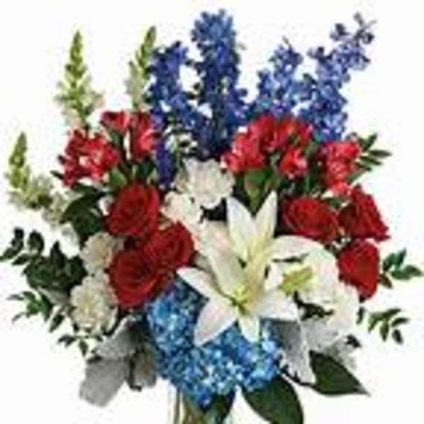 Bouquet of red, white, and blue flowers in a clear vase