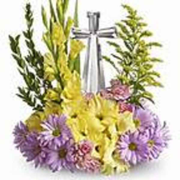 Standing floral spray with yellow and purple flowers and a silver ribbon cross