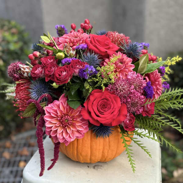 Bright mixed bouquet arranged in a pumpkin container