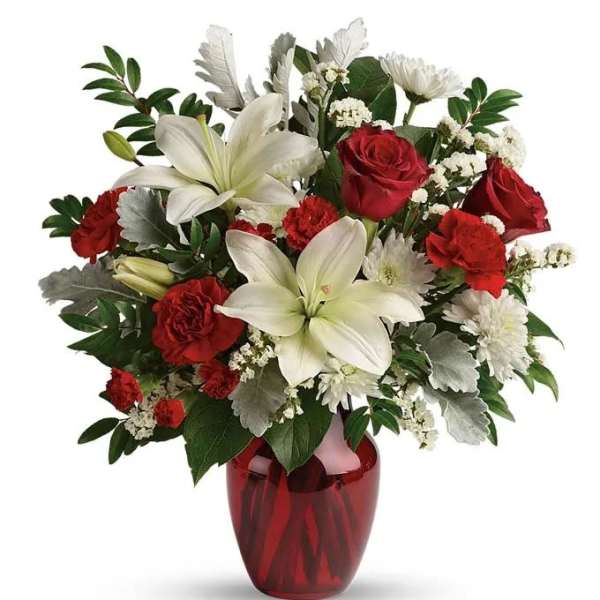 Red roses and white lilies in a red glass vase