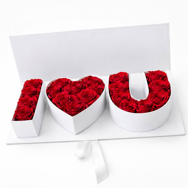 Red roses arranged in white boxes spelling I love you