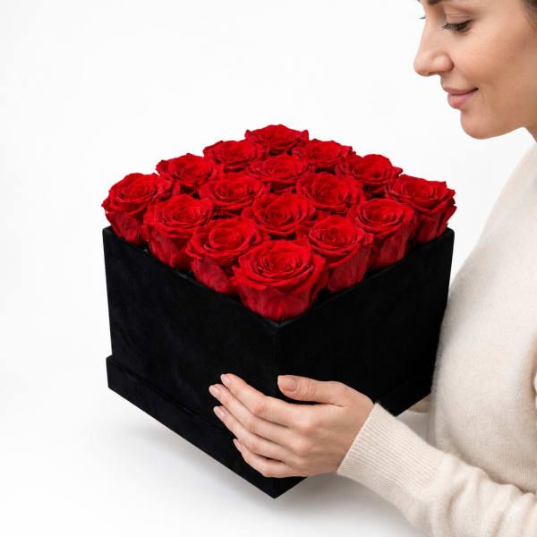 Woman holding a black box filled with red roses