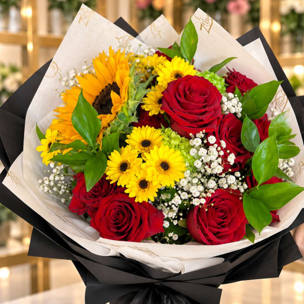 Bouquet of red roses and yellow daisies wrapped in black and white paper