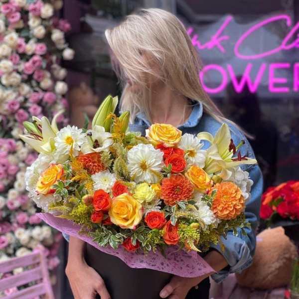 Large mixed bouquet of yellow, orange, and white flowers in a black box