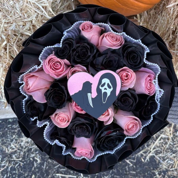 Pink and black rose bouquet with a heart-shaped horror movie topper